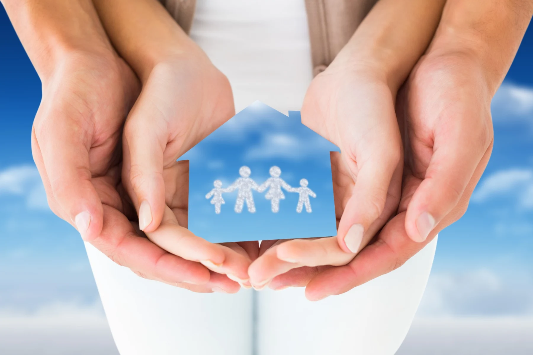 Manos protegiendo una casa y una familia